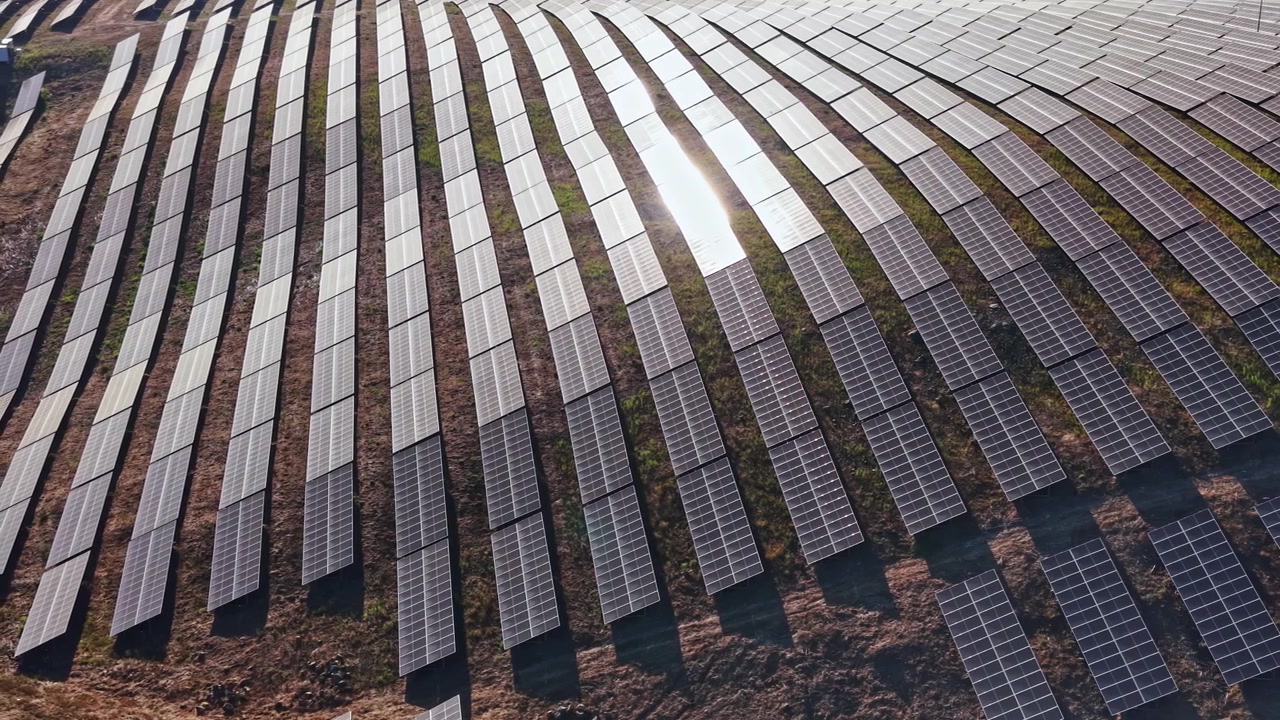 Solpaneler dækker et stort landområde i en vedvarende energipark i dagtimerne og leverer ren energi