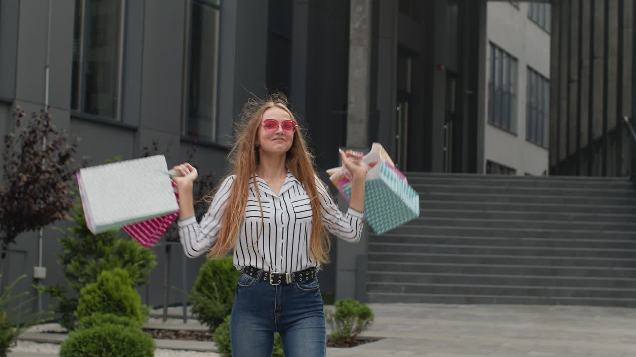 chica levantando bolsas de compras, pareciendo satisfecha con la compra, disfrutando de descuentos en el viernes negro