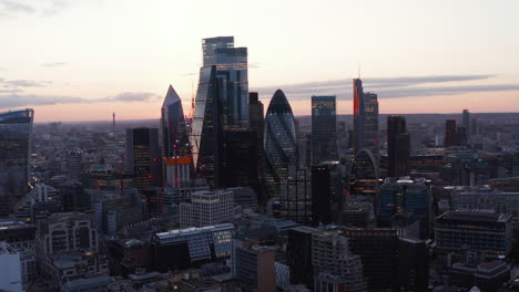 City-business-hub.-Modern-glass-covered-tall-iconic-buildings-in-evening-light-after-sunset.--London,-UK