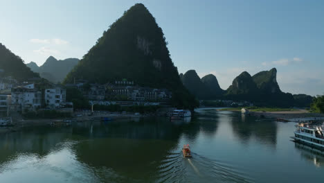 aerial view following a boat on li river, in front of yangshuo, sunset in china