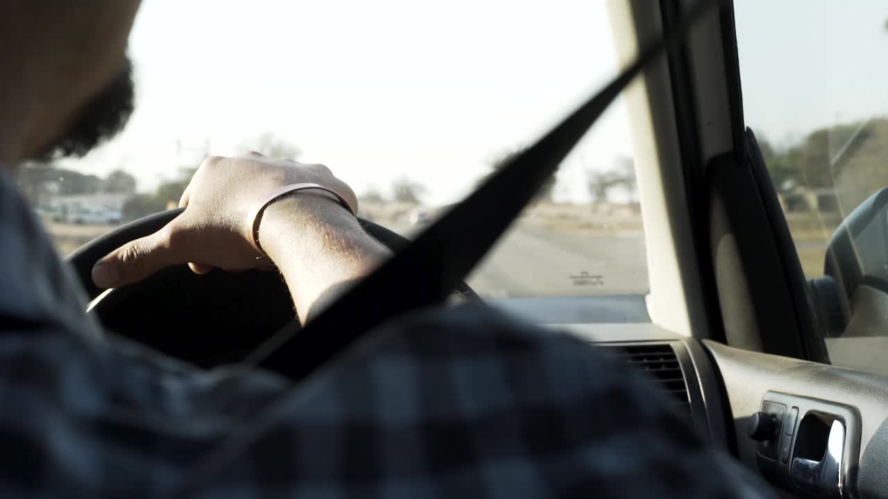 primer plano de un hombre conduciendo y girando el volante