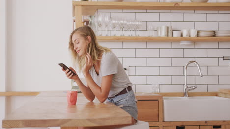 woman adjusting her hair behind her ear while using smart phone at home