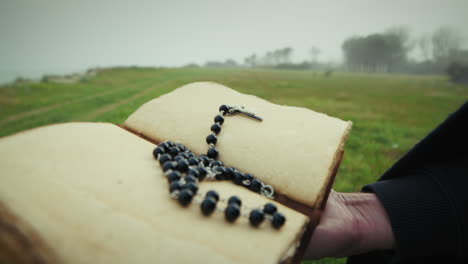 open christian religious book read by man in dull park