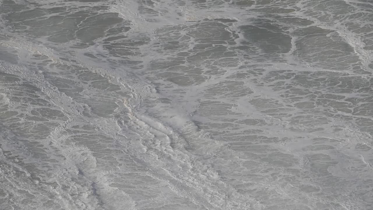 Enormous waves crashing in Nazare, Portugal, showcasing the power of nature's forces