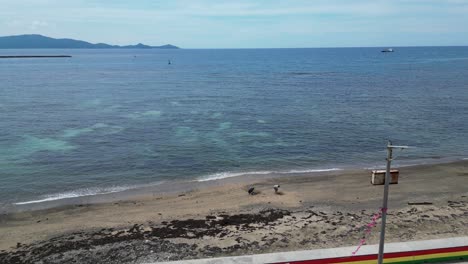 Absteigende,-Atemberaubende-Luftaufnahme-Der-Inselstadt-Und-Des-Uferdamms-Mit-Blick-Auf-Wunderschönes,-Klares-Meerwasser-Und-Einen-Idyllischen-Strand