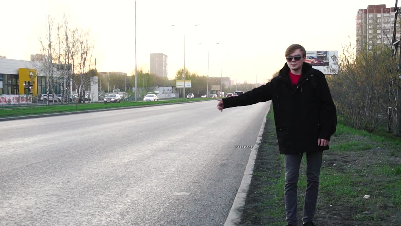 Man Hitchhiking on a City Street