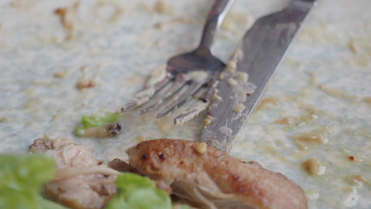 Leftover food on a plate with cutlery