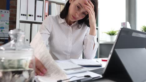 mujer deprimida triste mirando las cuentas financieras de cerca