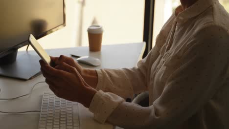 Businesswoman-using-mobile-phone-at-desk-4k