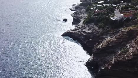 Drone-aerial-pan-up-sunset-beach-front-cliff-side