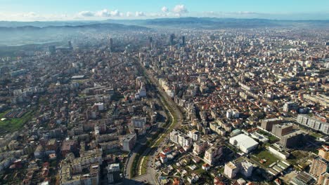 Zentrum-Mit-Hohen-Gebäuden-Und-Den-Außenbezirken-Der-Hauptstadt,-Verbunden-Durch-Den-Fluss-Lana-In-Tirana,-Albanien