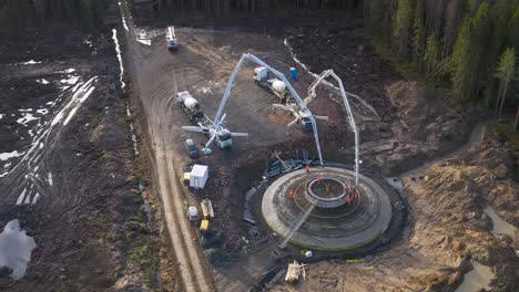 vertido de una base de hormigón para un fundamento de una megaestructura en medio de un bosque, proceso de construcción de la turbina eólica