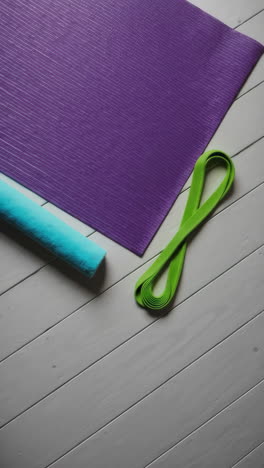 yoga mat, resistance band, and exercise accessories on wooden floor