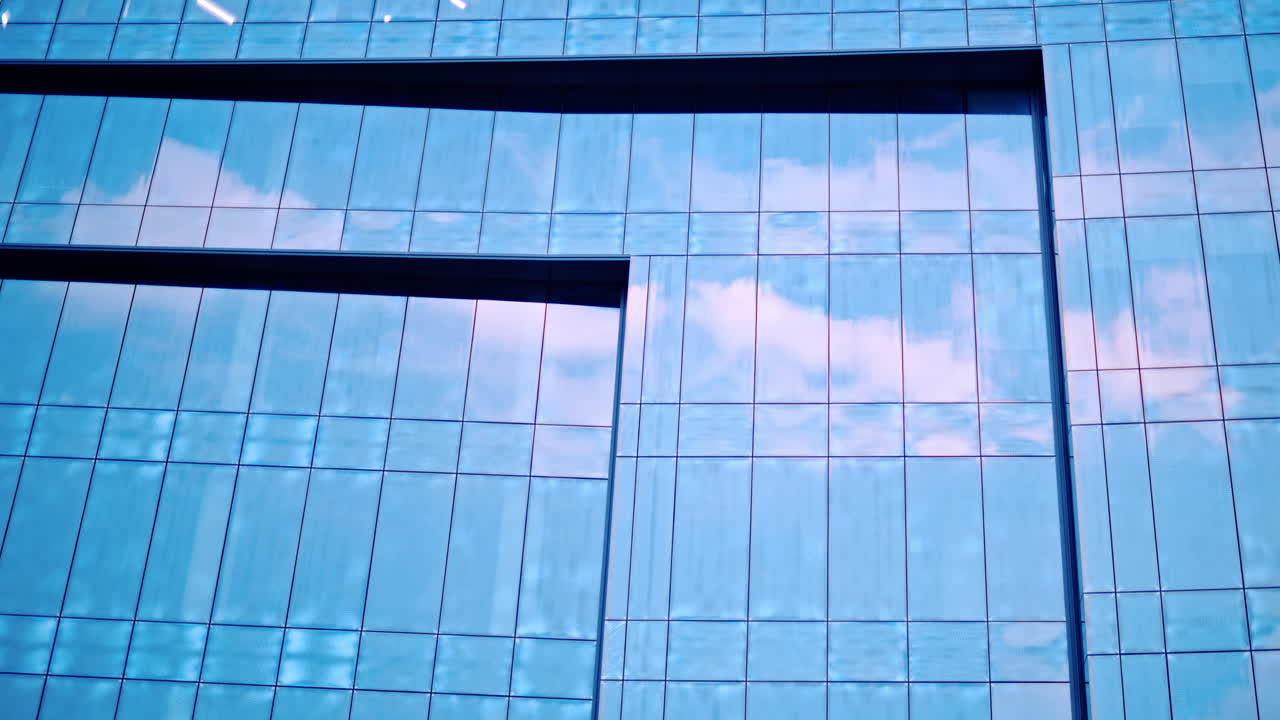 Il cielo si riflette su un edificio con pareti di vetro