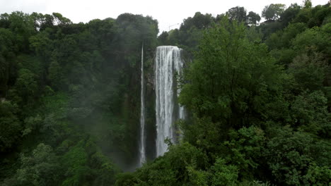 Marmore-Falls-Behind-The-Trees-With-Green-Foliage-In-The-Forest-In-Umbria,-Italy