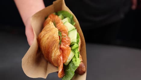 handheld salmon croissant sandwich