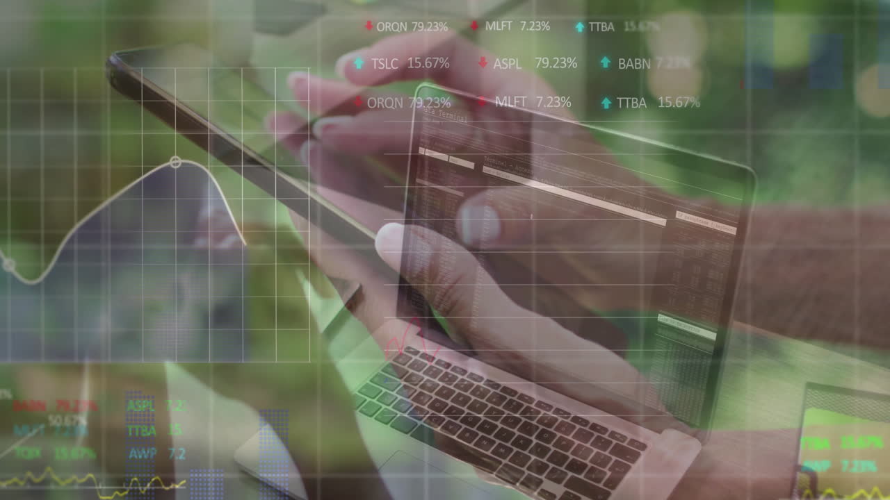 Hands using laptop and tablet with financial data processing animation overlay