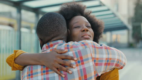 close-up view of happy african american young couple meeting at train station and hugging on nice summer day