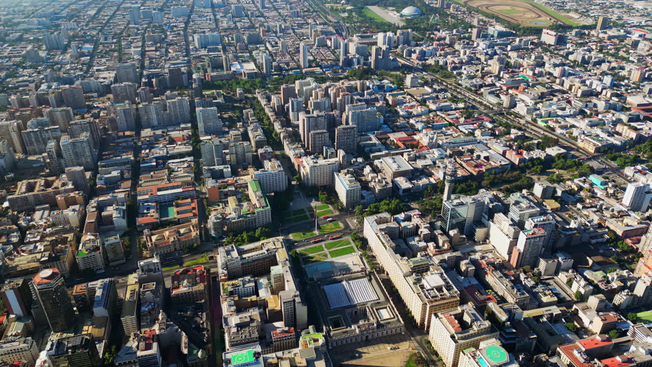 Aerial drone view of the organized grid and high rise skyline of central Santiago under clear daylight