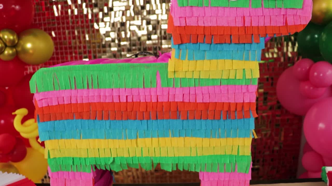 Piñata burrito messicana con decorazioni di palloncini e sfondo dorato in primo piano