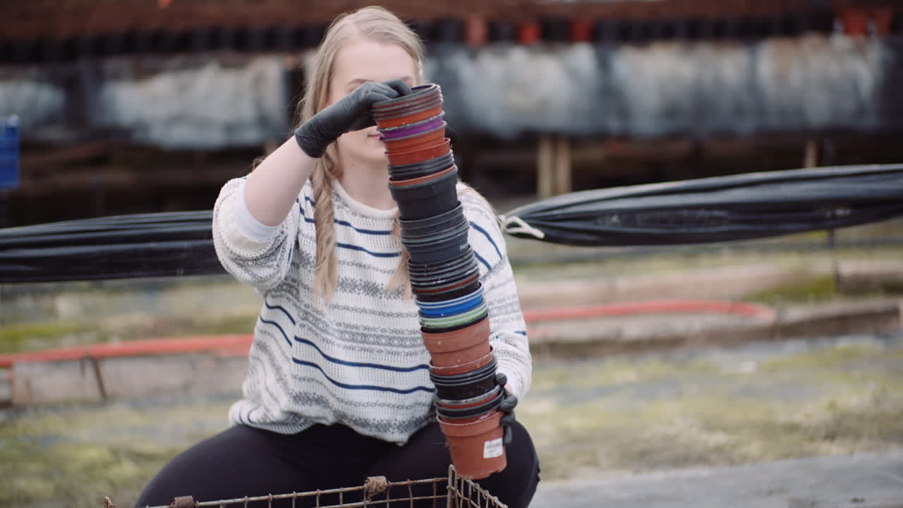 садовник сортирует горшки в теплице 1