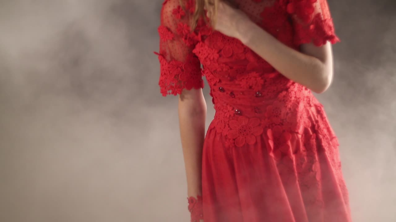 Beautiful Woman Over Smoky Background. Beautiful woman in red dress over smoky background