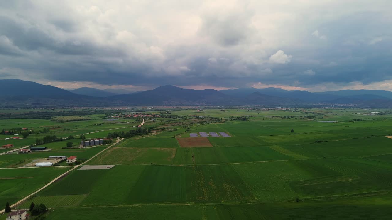 Aerial View of Serene Farmland and Mountains Under a Cloudy Sky
