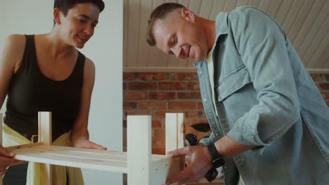 couple assembling wooden crate in kitchen