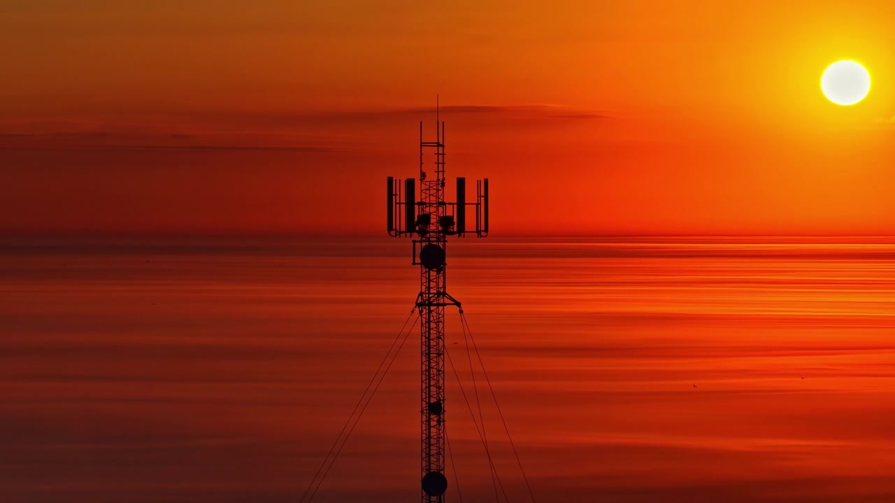 Sendemast med en orange aftenhimmel i Letland.