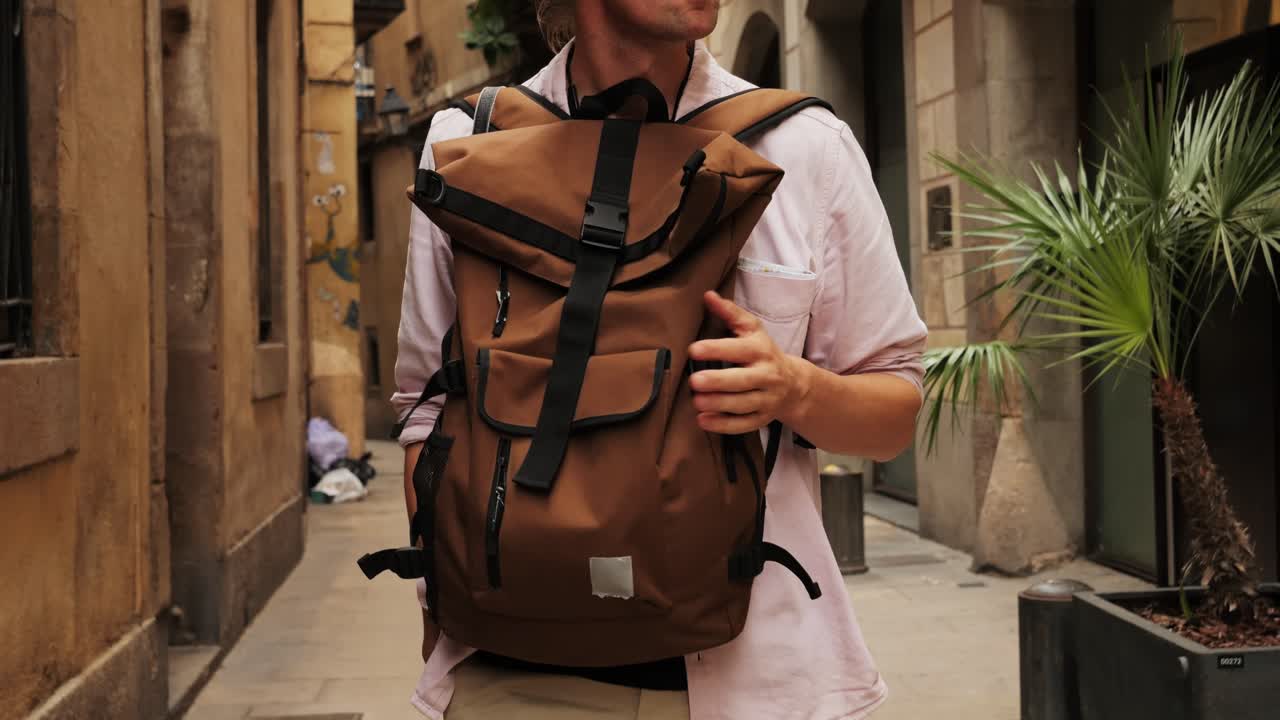 Happy tourist man in Barcelona, Spain. Vacation exploring interesting places to travel, student vacation, young man portrait walking in gothic square, old european city