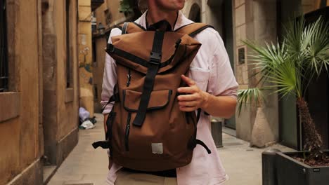 happy tourist man in barcelona, spain. vacation exploring interesting places to travel, student vacation, young man portrait walking in gothic square, old european city