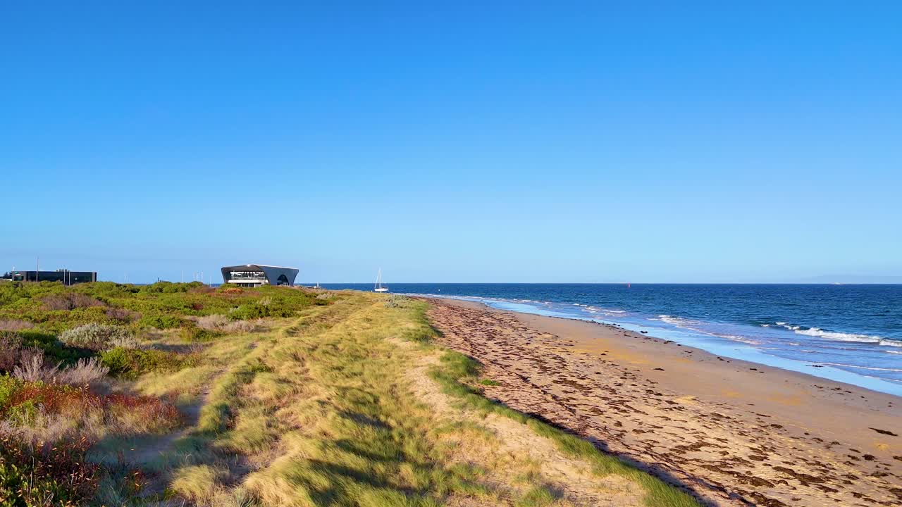 Aerial footage captures the serene coastline of Bellarine Peninsula under clear blue skies, highlighting sandy beaches and lush greenery