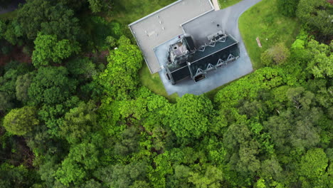 Aerial-down-shot-of-the-Kylemore-Abbey-and-a-bright,-green-forest-in-Ireland