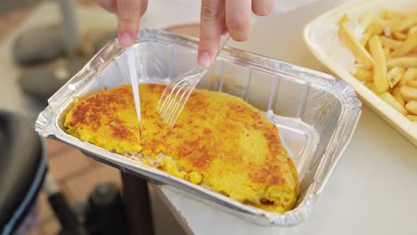 Person-uses-plastic-tools-to-cut-Cachapa-take-away-food,-close-up