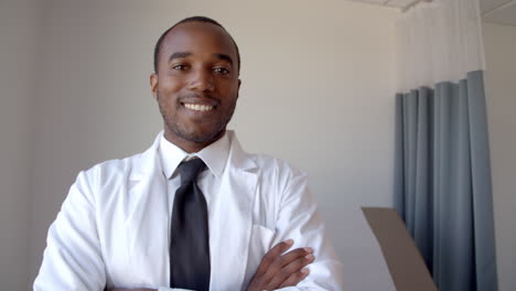 portrait of male doctor wearing white coat in exam room