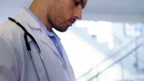 doctor using digital tablet in corridor