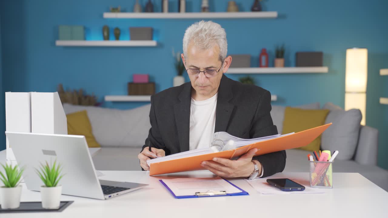 Uomo in smart working che guarda il file con rabbia