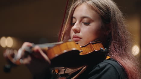 retrato en primer plano de una hermosa violinista mujer violinista está tocando el violín en la casa de la ópera