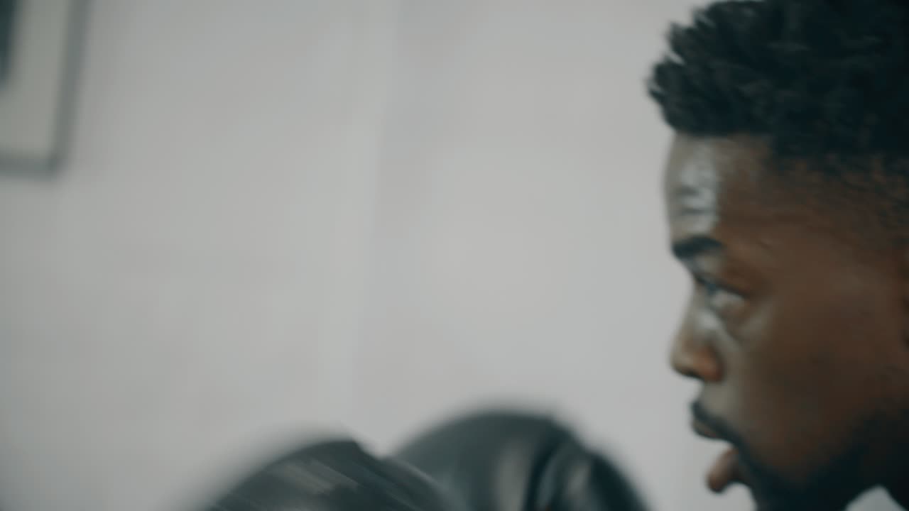 cu of mans cara mientras golpea saco de boxeo