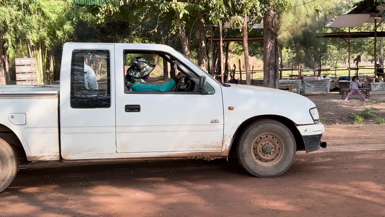 un camión blanco viaja por un camino de tierra