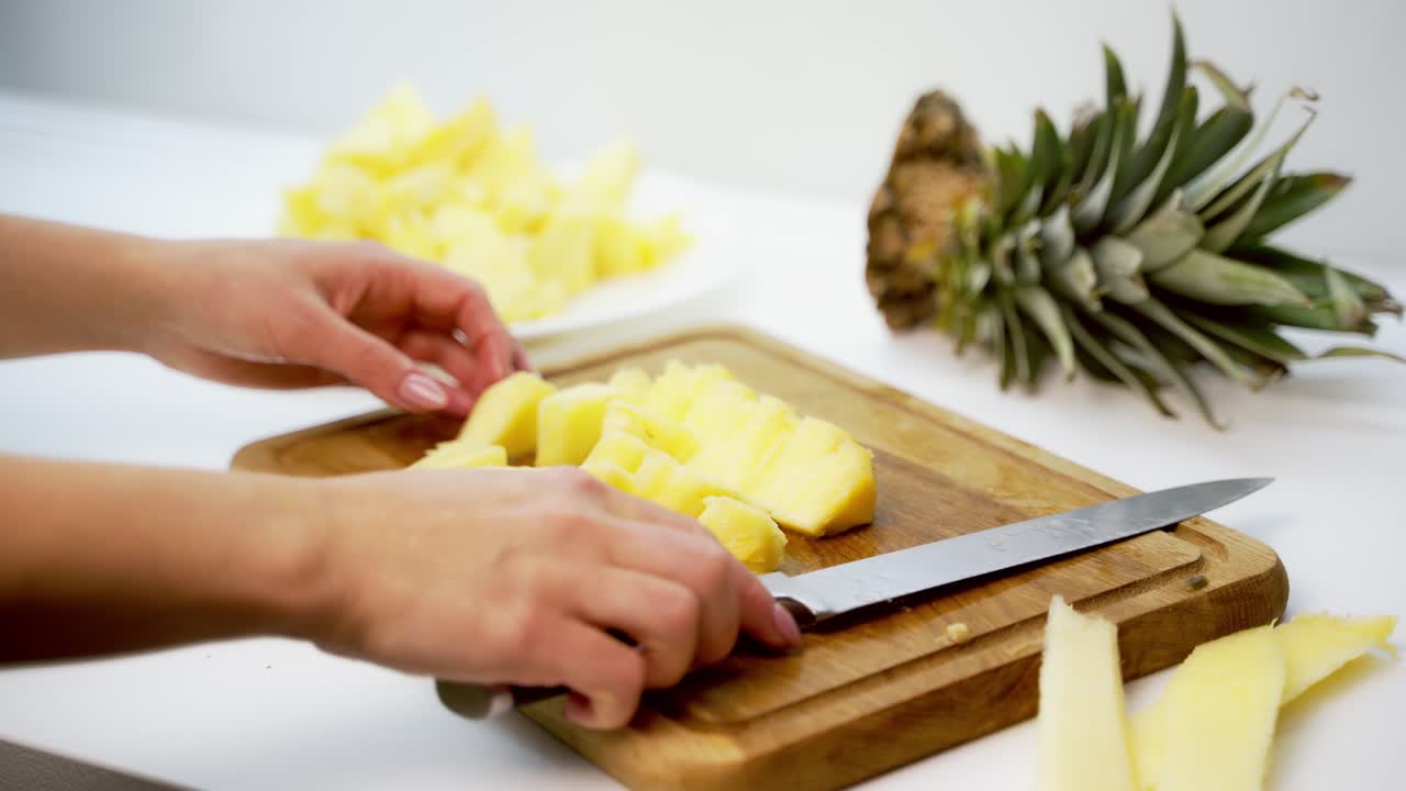 Board with delicious cut pineapple on table. Composition with fresh ripe pineapples on white background