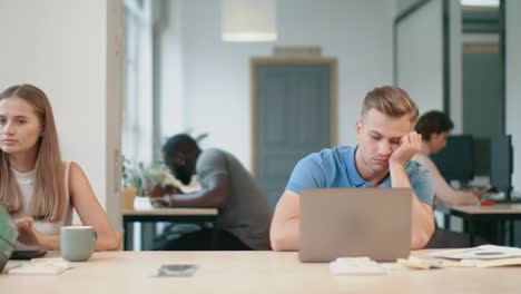 young man feeling sleepy at coworking. portrait of business man falling asleep