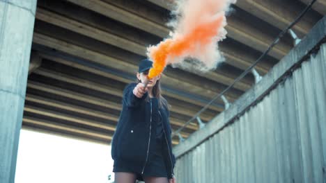 girl in cap protesting on street with smoke bomb. woman holding smoke grenade