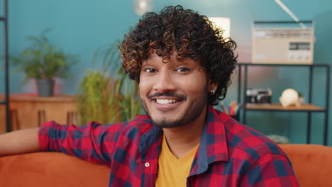 smiling playful happy young indian man blinking eye, looking at camera with smile, winking, flirting