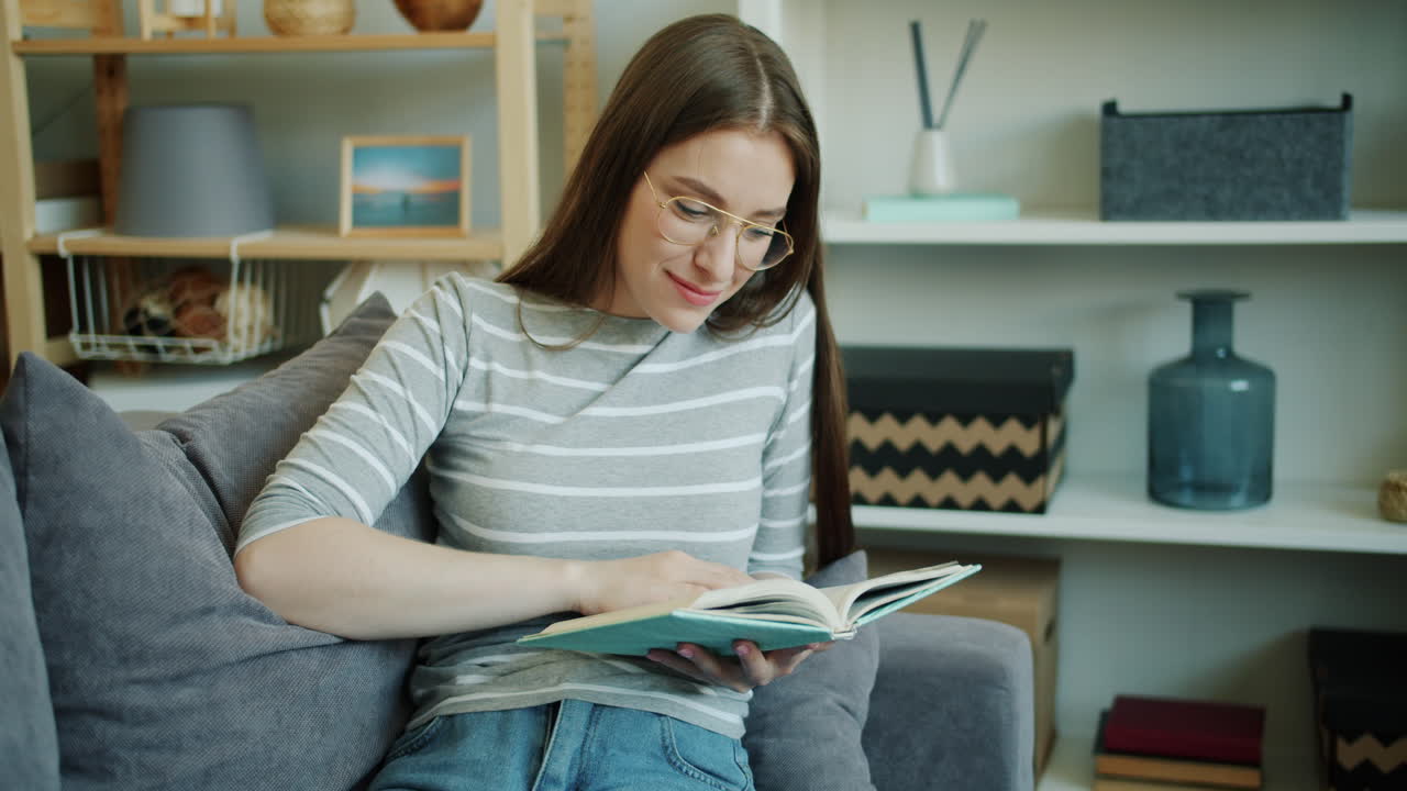 Eine Frau liest ein Buch auf einer Couch