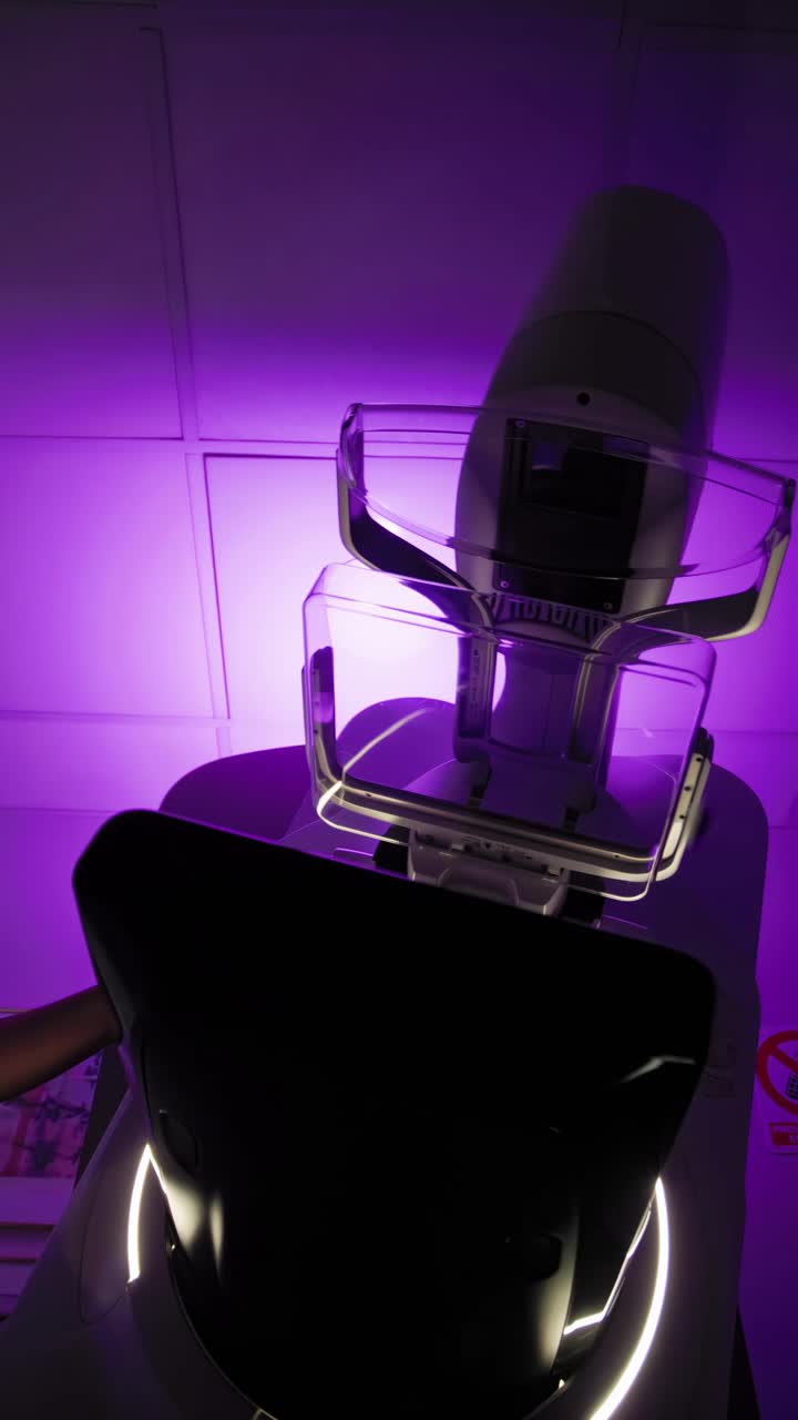 Mammography medical equipment is activated with a violet background light inside a doctor's office at a clinic