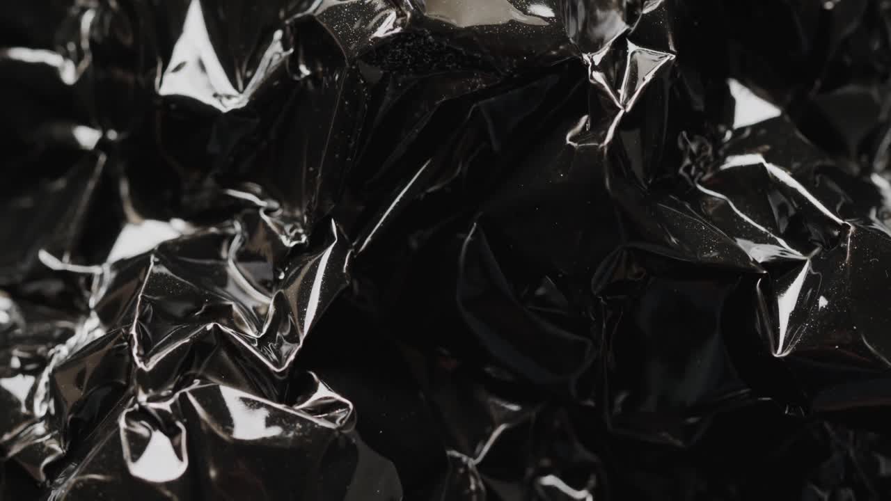 Close-up de saco de lixo plástico preto amassado em câmera lenta