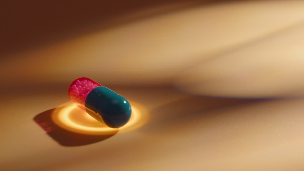 bicolour pill antibiotics split in red and blue rotate with golden energy healing circle of light