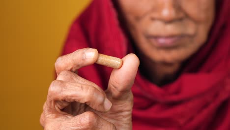 elderly woman holding a capsule