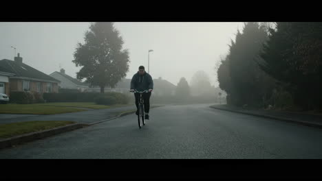 Foggy road with cyclist and houses